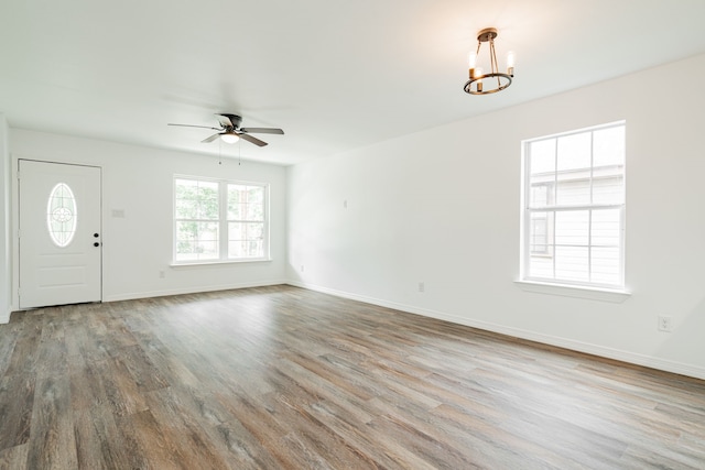 interior space featuring wood-type flooring and ceiling fan with notable chandelier