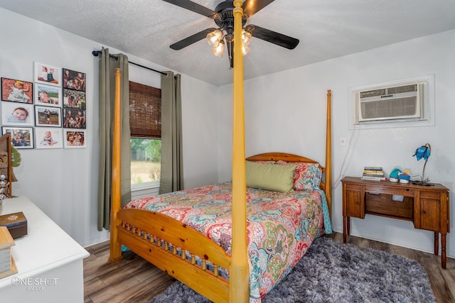 bedroom with a wall mounted air conditioner, a textured ceiling, ceiling fan, and hardwood / wood-style floors