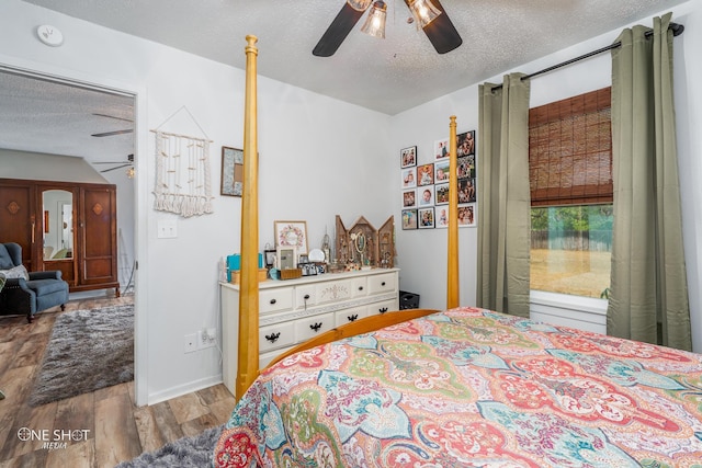 bedroom featuring light hardwood / wood-style floors, a textured ceiling, and ceiling fan