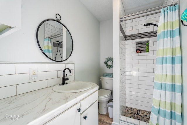 bathroom with backsplash, a textured ceiling, toilet, vanity, and curtained shower