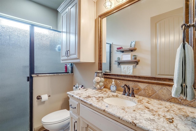 bathroom featuring decorative backsplash, vanity, and toilet