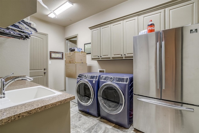 clothes washing area with cabinets, independent washer and dryer, and sink