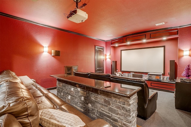 cinema room with carpet, bar area, a textured ceiling, and ornamental molding