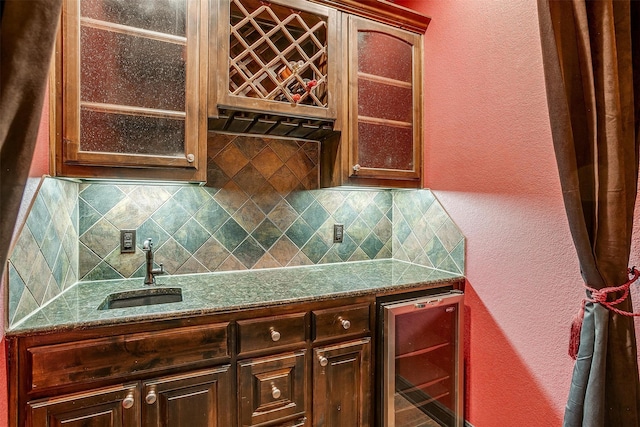 kitchen featuring backsplash, wine cooler, and sink