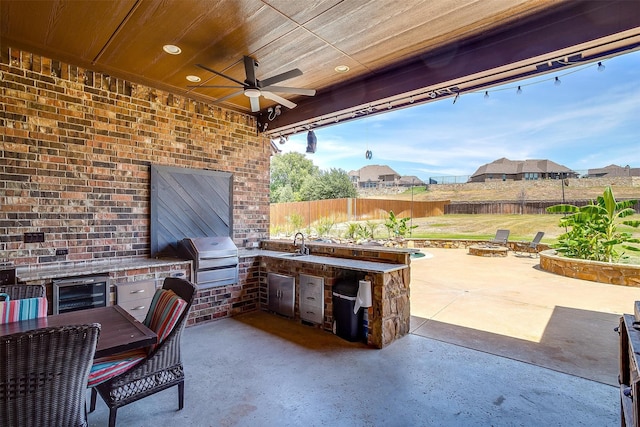 view of patio / terrace with a fire pit, ceiling fan, area for grilling, and sink