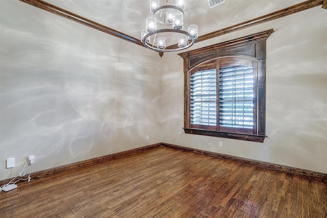 empty room featuring hardwood / wood-style floors, an inviting chandelier, and ornamental molding