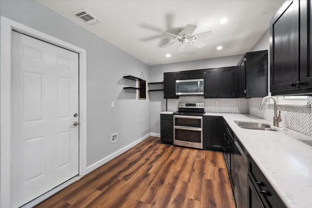 kitchen featuring stainless steel appliances, tasteful backsplash, sink, and dark wood-type flooring