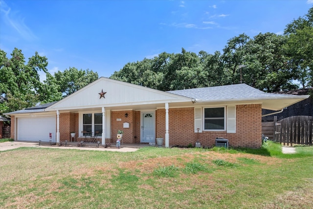 single story home featuring a garage, covered porch, and a front lawn