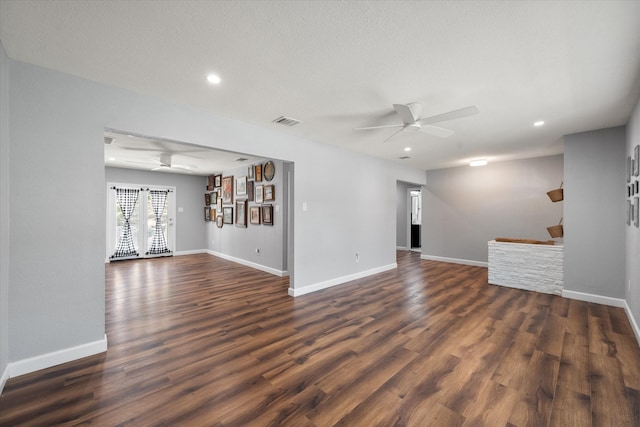 unfurnished living room with dark hardwood / wood-style floors, ceiling fan, and a textured ceiling