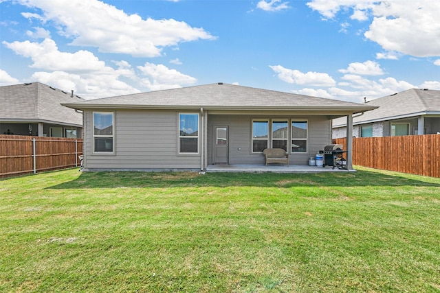 rear view of house featuring a lawn and a patio area