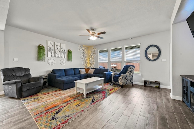 living room featuring ceiling fan, wood-type flooring, and a textured ceiling