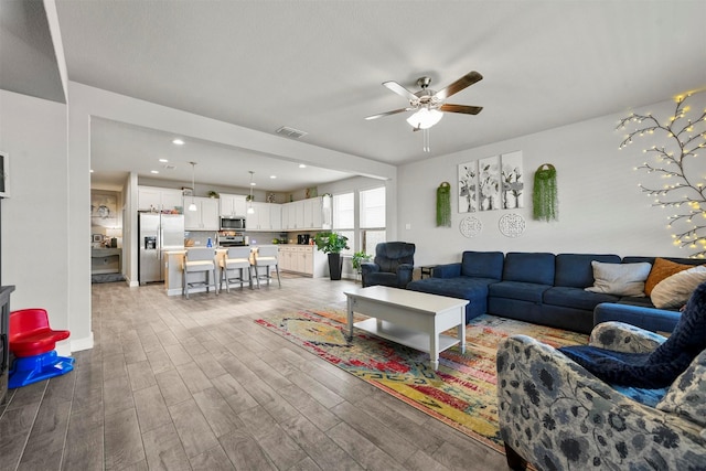 living room featuring ceiling fan and light wood-type flooring