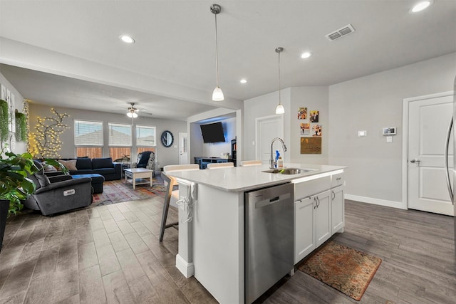 kitchen featuring pendant lighting, dishwasher, a kitchen island with sink, white cabinets, and sink