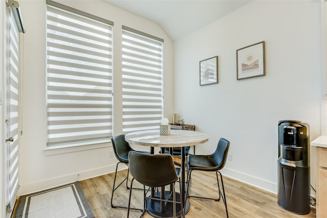 dining space featuring light hardwood / wood-style floors and vaulted ceiling