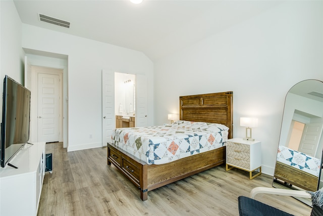 bedroom featuring ensuite bathroom and light hardwood / wood-style floors