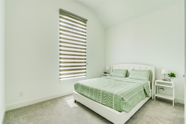 carpeted bedroom with lofted ceiling