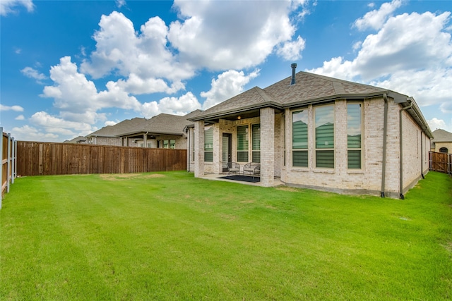 back of house with a yard and a patio