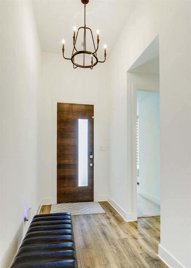 entrance foyer with light hardwood / wood-style flooring and a chandelier