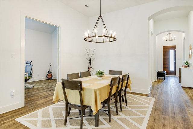 dining room with light hardwood / wood-style flooring and a notable chandelier