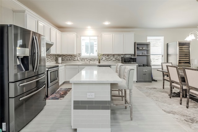 kitchen featuring decorative backsplash, pendant lighting, white cabinetry, and appliances with stainless steel finishes