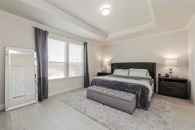 bedroom with crown molding, light hardwood / wood-style flooring, and a raised ceiling