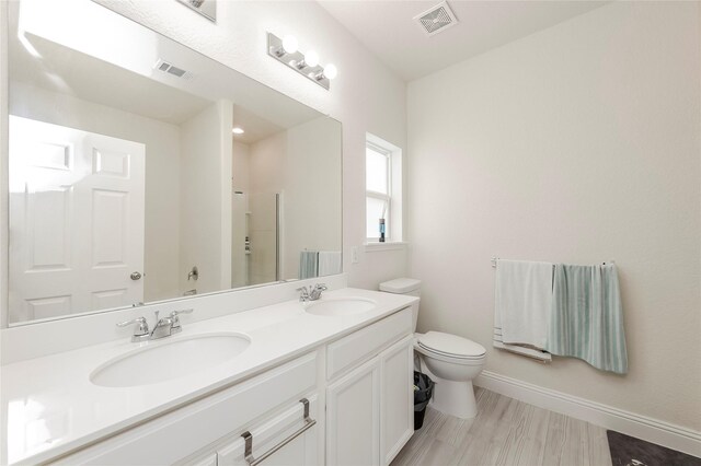 full bathroom featuring toilet, a sink, and visible vents