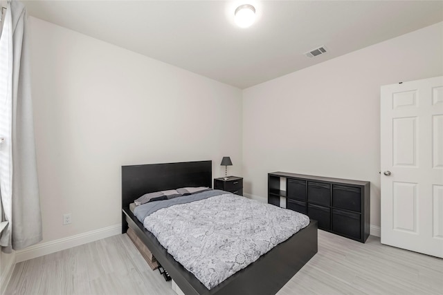bedroom featuring light wood-style floors, baseboards, and visible vents