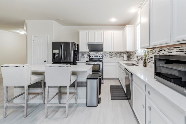 kitchen featuring white cabinetry, appliances with stainless steel finishes, crown molding, and tasteful backsplash