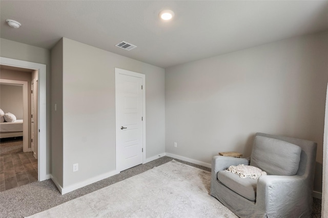 sitting room featuring light carpet, baseboards, and visible vents