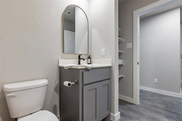 bathroom featuring hardwood / wood-style flooring, toilet, and vanity