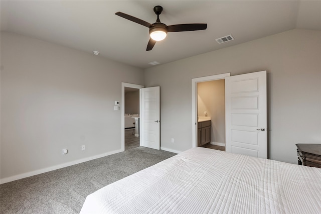 carpeted bedroom with ensuite bath, ceiling fan, and vaulted ceiling