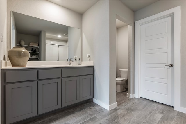 bathroom featuring vanity, toilet, and hardwood / wood-style floors