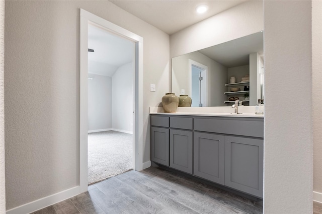 bathroom featuring wood finished floors, vanity, and baseboards