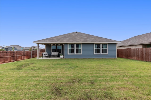 rear view of house with a patio and a lawn