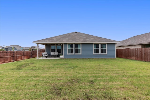 rear view of property with a fenced backyard, a lawn, and a patio