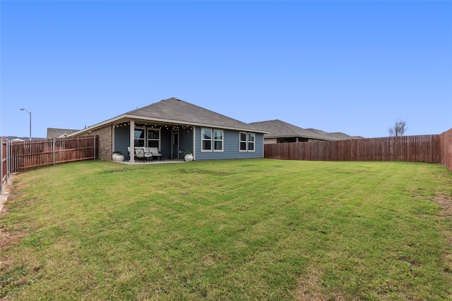 back of house with a yard and a patio