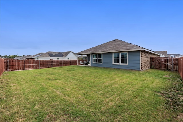 back of house featuring a fenced backyard and a yard