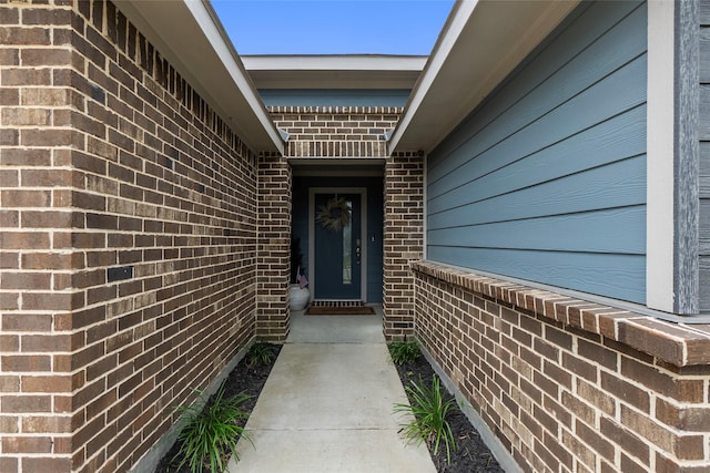 view of exterior entry with brick siding