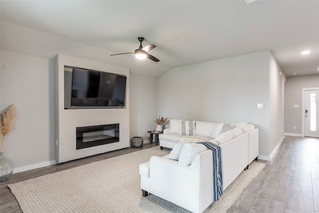 living room featuring vaulted ceiling, ceiling fan, and light hardwood / wood-style floors