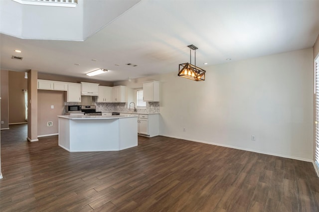 kitchen with a kitchen island, pendant lighting, white cabinets, and appliances with stainless steel finishes