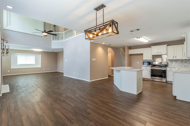 kitchen with white cabinets, dark hardwood / wood-style floors, a center island, and stainless steel range with electric cooktop