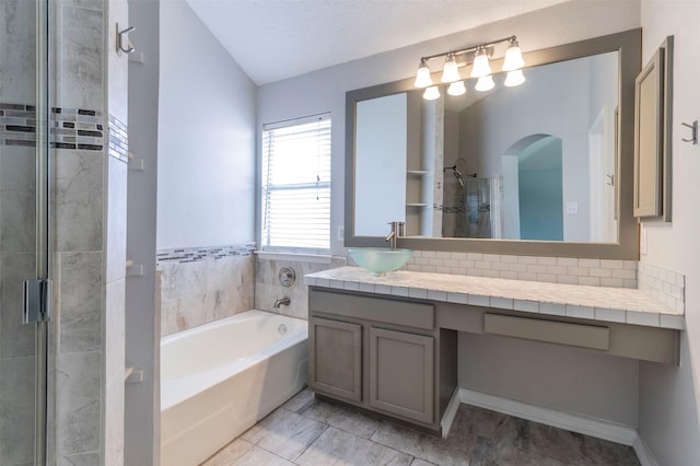 bathroom with vanity, lofted ceiling, independent shower and bath, and a textured ceiling