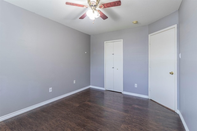 unfurnished bedroom with dark wood-type flooring, a closet, and ceiling fan