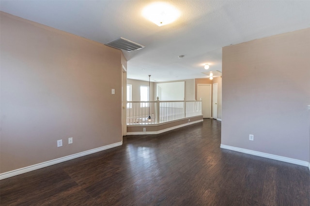 empty room with ceiling fan and dark wood-type flooring