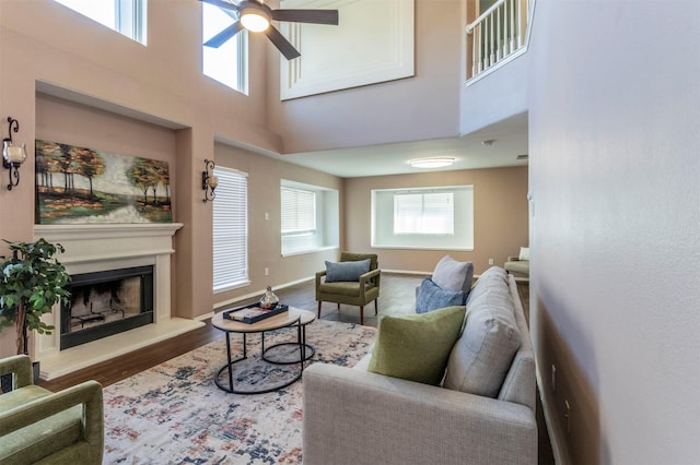 living room featuring a high ceiling, hardwood / wood-style flooring, and ceiling fan