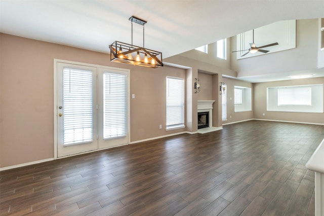 unfurnished living room with ceiling fan and dark wood-type flooring