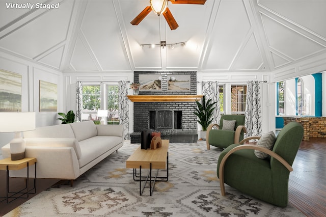 living room with lofted ceiling, ceiling fan, hardwood / wood-style flooring, and a fireplace