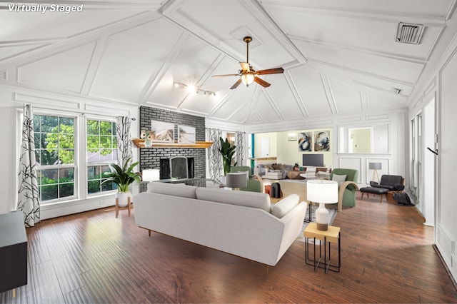 living room featuring a fireplace, vaulted ceiling, dark hardwood / wood-style flooring, and ceiling fan