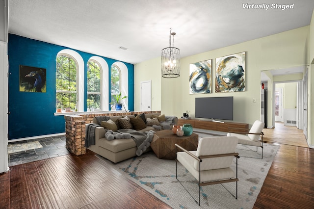 living room with dark wood-type flooring and a chandelier