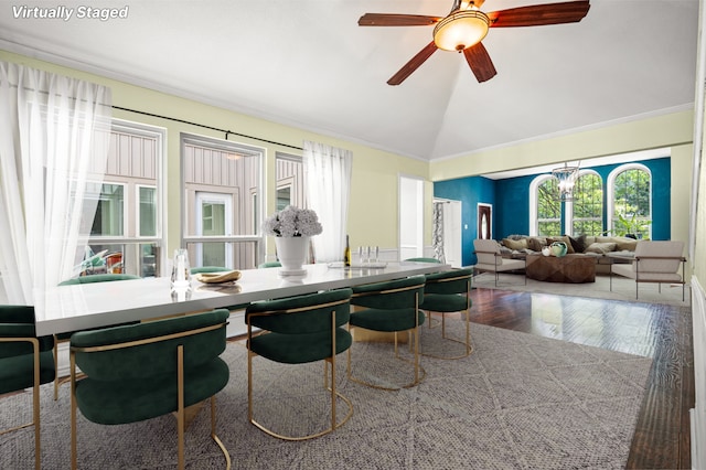 dining area with hardwood / wood-style floors, ceiling fan with notable chandelier, and vaulted ceiling